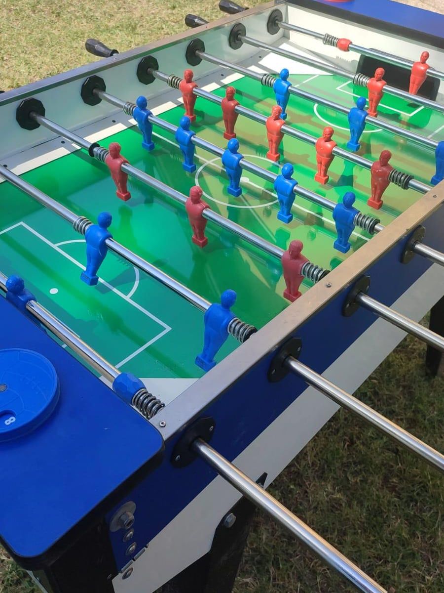 Calcio balilla con omini rossi e blu, montato all'aperto sul prato
