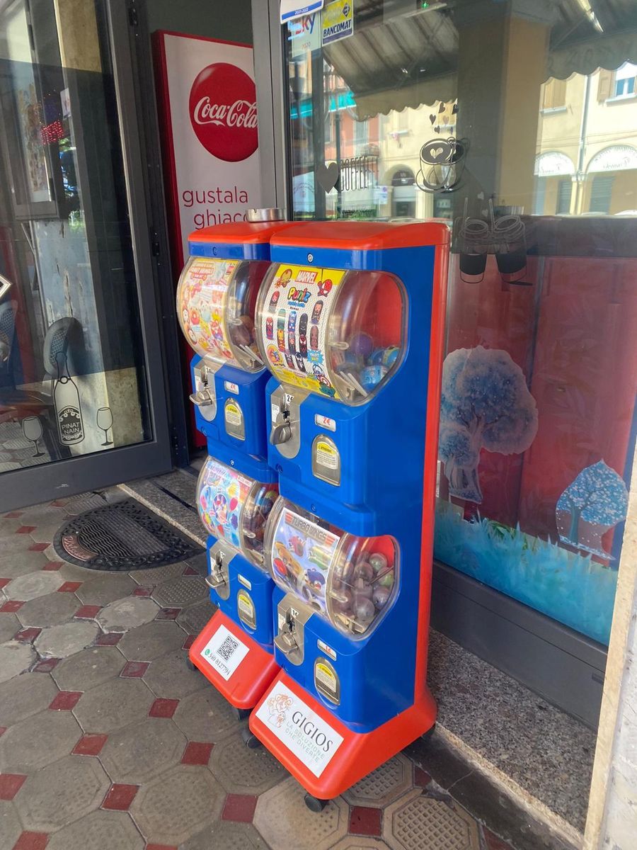 Due distributori di palline con l'etichetta Gigios all'ingresso di un bar