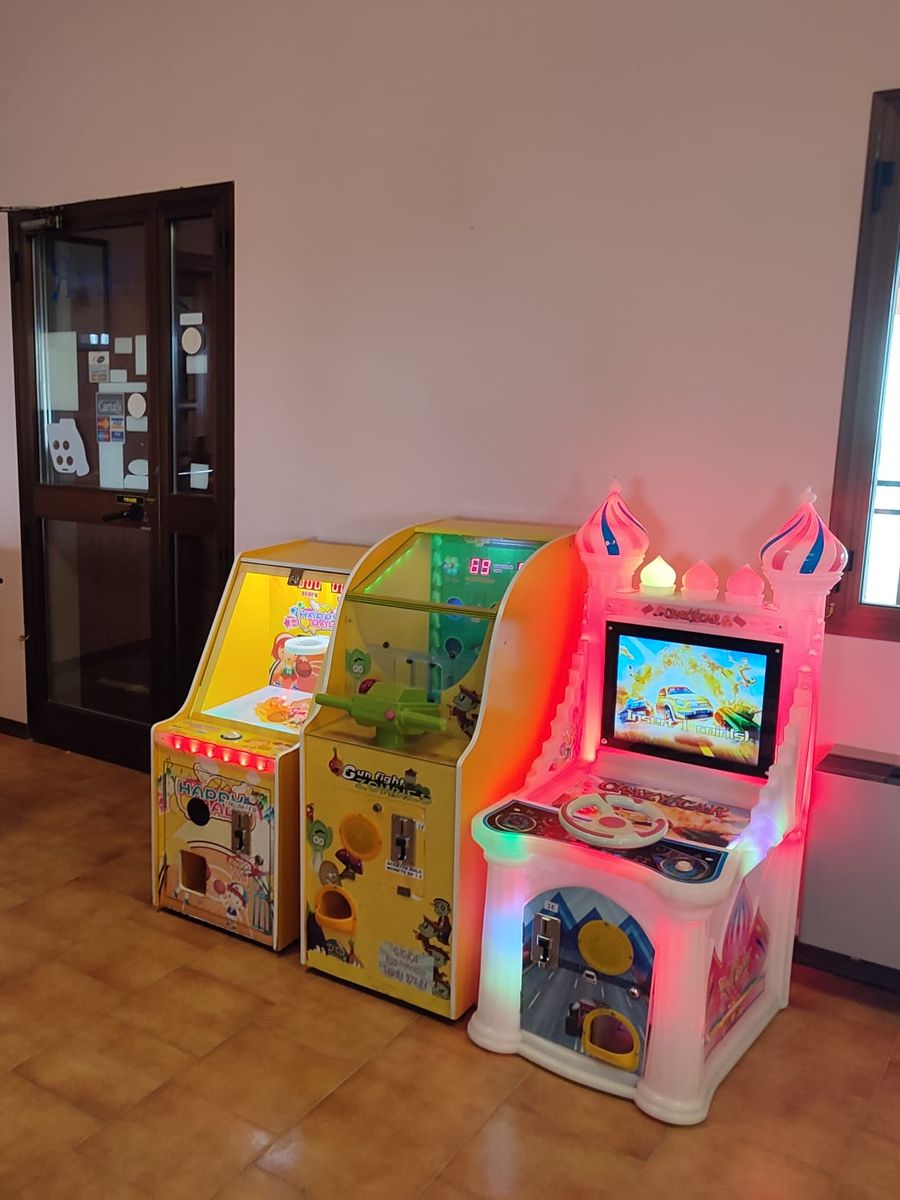 Tre giochi elettronici per bambini, uno a forma di castello, allestiti in una sala di un locale